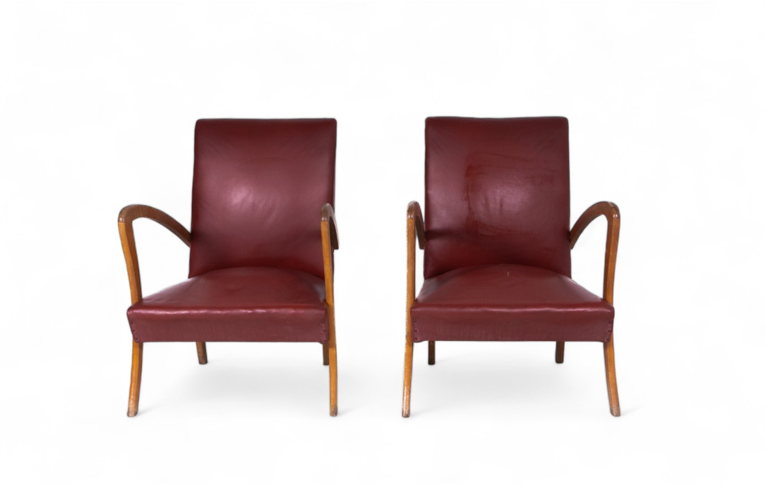Two burgundy faux leather armchairs